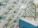 Stylish powder room with blue vanity, gold fixtures, designer wallpaper, and decorative gold mirror at 2129 Halford Pl, Charlotte, NC 28211
