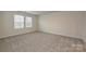 This bedroom features neutral carpet, paint and two sunny windows at 2159 Sunflower Cir, Newton, NC 28658