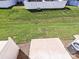 Aerial view of a townhome backyard featuring a small patio, lawn, and a white privacy fence in a neighborhood at 2715 Sydney Overlook Ln, Charlotte, NC 28269