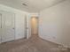 Neutral bedroom with an open doorway, carpet, and multiple electrical outlets at 2715 Sydney Overlook Ln, Charlotte, NC 28269