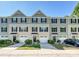 Exterior view of townhomes featuring two-car garages, shutters, landscaping, and sidewalks at 2715 Sydney Overlook Ln, Charlotte, NC 28269