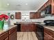 Well-equipped kitchen with dark wood cabinets, black appliances, and ample counter space at 2715 Sydney Overlook Ln, Charlotte, NC 28269