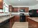 Functional kitchen featuring dark cabinets, black appliances, and durable countertops for easy meal preparation at 2715 Sydney Overlook Ln, Charlotte, NC 28269