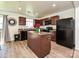 Spacious kitchen with an island, dark cabinetry, black appliances and view to dining area at 2715 Sydney Overlook Ln, Charlotte, NC 28269