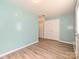 A clean, bright room with light blue walls, wood-look flooring, and closet space at 2715 Sydney Overlook Ln, Charlotte, NC 28269
