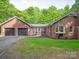Exterior view of a brick home with attached garage and screened in porch at 300 Hugh Crocker Rd, Matthews, NC 28104