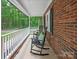 Quaint front porch featuring rocking chairs, complemented by a charming brick facade and a peaceful outdoor setting at 300 Hugh Crocker Rd, Matthews, NC 28104