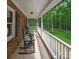 Relaxing porch with rocking chairs, offering a serene view of the surrounding greenery and a classic brick exterior at 300 Hugh Crocker Rd, Matthews, NC 28104