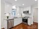 Modern kitchen featuring white cabinetry, stainless steel appliances, granite countertops, and hardwood floors at 300 Hugh Crocker Rd, Matthews, NC 28104