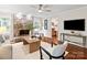 Cozy living room with a stone fireplace, ceiling fan, hardwood floors, and comfortable seating arrangement at 300 Hugh Crocker Rd, Matthews, NC 28104