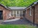 Charming brick patio with a screened-in porch, framed by flowers and mulch beds enhancing the home's appeal at 300 Hugh Crocker Rd, Matthews, NC 28104