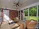 Inviting sunroom featuring ceiling fan, brick wall, screened windows and furniture at 300 Hugh Crocker Rd, Matthews, NC 28104