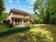Brick home with a lush backyard, stone patio, and screen porch is perfect for entertaining and relaxation at 3825 Mountain Cove Dr, Charlotte, NC 28216