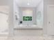 Bright bathroom showcasing a soaking tub with a large window and tiled surround at 3825 Mountain Cove Dr, Charlotte, NC 28216