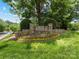 Stone entrance to Overlook Swim & Tennis Club with manicured landscaping and a lush, green lawn at 3825 Mountain Cove Dr, Charlotte, NC 28216