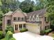 A stately brick home features a two-car garage, mature landscaping, and a welcoming front porch at 3825 Mountain Cove Dr, Charlotte, NC 28216
