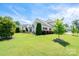 Expansive backyard featuring lush lawn, mature trees, and a stone patio with outdoor kitchen at 4321 Tucker Chase Dr, Midland, NC 28107