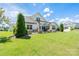 Landscaped backyard with mature trees, green lawn, and a outdoor patio at 4321 Tucker Chase Dr, Midland, NC 28107