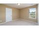 Empty carpeted bedroom with a window for natural light and a neutral color paint at 4321 Tucker Chase Dr, Midland, NC 28107