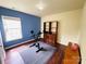 Bedroom featuring dark wood floors, blue accent wall, and workout bike near the large window at 4698 Hannah Dr, Rock Hill, SC 29732