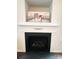 Close-up of a fireplace featuring a black interior and mantle with decorative accents and artwork above at 4698 Hannah Dr, Rock Hill, SC 29732