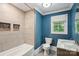 Stylish bathroom featuring blue walls, a shower niche, and a modern vanity with marble countertop at 500 Peigler Nw St, Concord, NC 28027