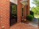 Close-up of brick entrance featuring potted plants, glass storm door, and well-maintained exterior at 532 Wilmslow Rd, Rock Hill, SC 29730