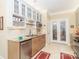 Well-lit kitchen featuring tan cabinets, granite countertops, stainless dishwasher and microwave, and white tile flooring at 532 Wilmslow Rd, Rock Hill, SC 29730