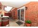 Cozy covered patio with brick walls, flower pots, and a sliding door leading inside at 532 Wilmslow Rd, Rock Hill, SC 29730