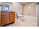 A well-maintained bathroom featuring a tiled shower-tub, wood cabinet, and a sleek toilet at 5833 Harris Grove Ln, Charlotte, NC 28212
