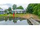 Waterfront condo building with lush greenery, mature trees, and serene pond views, offering a peaceful retreat at 5833 Harris Grove Ln, Charlotte, NC 28212