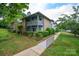Beautiful condo building with lush landscaping, a serene pond, and a private walkway for residents at 5833 Harris Grove Ln, Charlotte, NC 28212