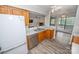 Open kitchen area with wooden cabinets, stainless steel appliances, and a view of the living room at 5833 Harris Grove Ln, Charlotte, NC 28212