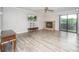 Bright living room features a brick fireplace, ceiling fan, and sliding glass doors to a balcony at 5833 Harris Grove Ln, Charlotte, NC 28212