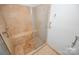 Elegant shower featuring neutral stone-look tile, glass door and shower bench at 5833 Harris Grove Ln, Charlotte, NC 28212
