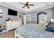 Comfortable bedroom featuring a ceiling fan, tray ceiling, a dresser, and a doorway to the bathroom at 6603 Havencrest Dr, Denver, NC 28037