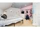 Cozy bedroom features a bed, white dresser, and black metal garment rack with hanging clothes at 6603 Havencrest Dr, Denver, NC 28037