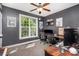 The home office features a window, a ceiling fan, a desk with two monitors, and dark gray walls at 6603 Havencrest Dr, Denver, NC 28037