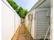 A narrow side yard with a gravel path and a white privacy fence at 7129 Stonington Ln, Charlotte, NC 28227