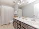 This bathroom has a double vanity with framed mirror, tiled floor, and a shower with curtain at 7318 Agnew Dr, Charlotte, NC 28278