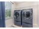 The laundry room offers modern appliances, a window, and a shelf for extra storage space at 7318 Agnew Dr, Charlotte, NC 28278