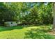 Expansive grassy backyard with mature trees, fire pit, hammock, and storage shed creating a serene outdoor space at 851 Gist Rd, Rock Hill, SC 29732