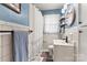 Charming bathroom featuring white tile, blue walls, and a stylish round mirror at 851 Gist Rd, Rock Hill, SC 29732