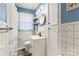 Bright bathroom with white tile, blue walls, and updated fixtures, including a round mirror and black faucet at 851 Gist Rd, Rock Hill, SC 29732