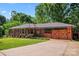 Charming brick home featuring a well-manicured lawn, lovely landscaping, and a uniquely designed garage door at 851 Gist Rd, Rock Hill, SC 29732