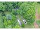 Aerial view of wooded property with house, driveway, outbuildings, and in-ground pool at 857 Hills Rd, Belmont, NC 28012