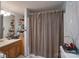 Bathroom with vanity and open shelves, featuring a bathtub with checkered shower curtain at 857 Hills Rd, Belmont, NC 28012