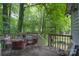 Back deck with metal table and four chairs nestled amongst lush greenery outdoors at 857 Hills Rd, Belmont, NC 28012