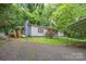 Cozy home with driveway, featuring a covered parking area and surrounded by vibrant landscaping and mature trees at 857 Hills Rd, Belmont, NC 28012