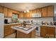 Bright kitchen with white appliances, wood cabinets, tile countertops, and an island at 857 Hills Rd, Belmont, NC 28012